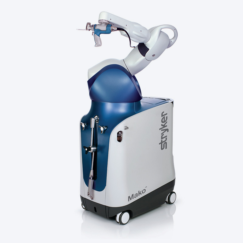 A white and blue medical robot labeled "Stryker Mako" with a robotic arm and wheels, designed for assisting in surgical procedures, is shown against a plain background.