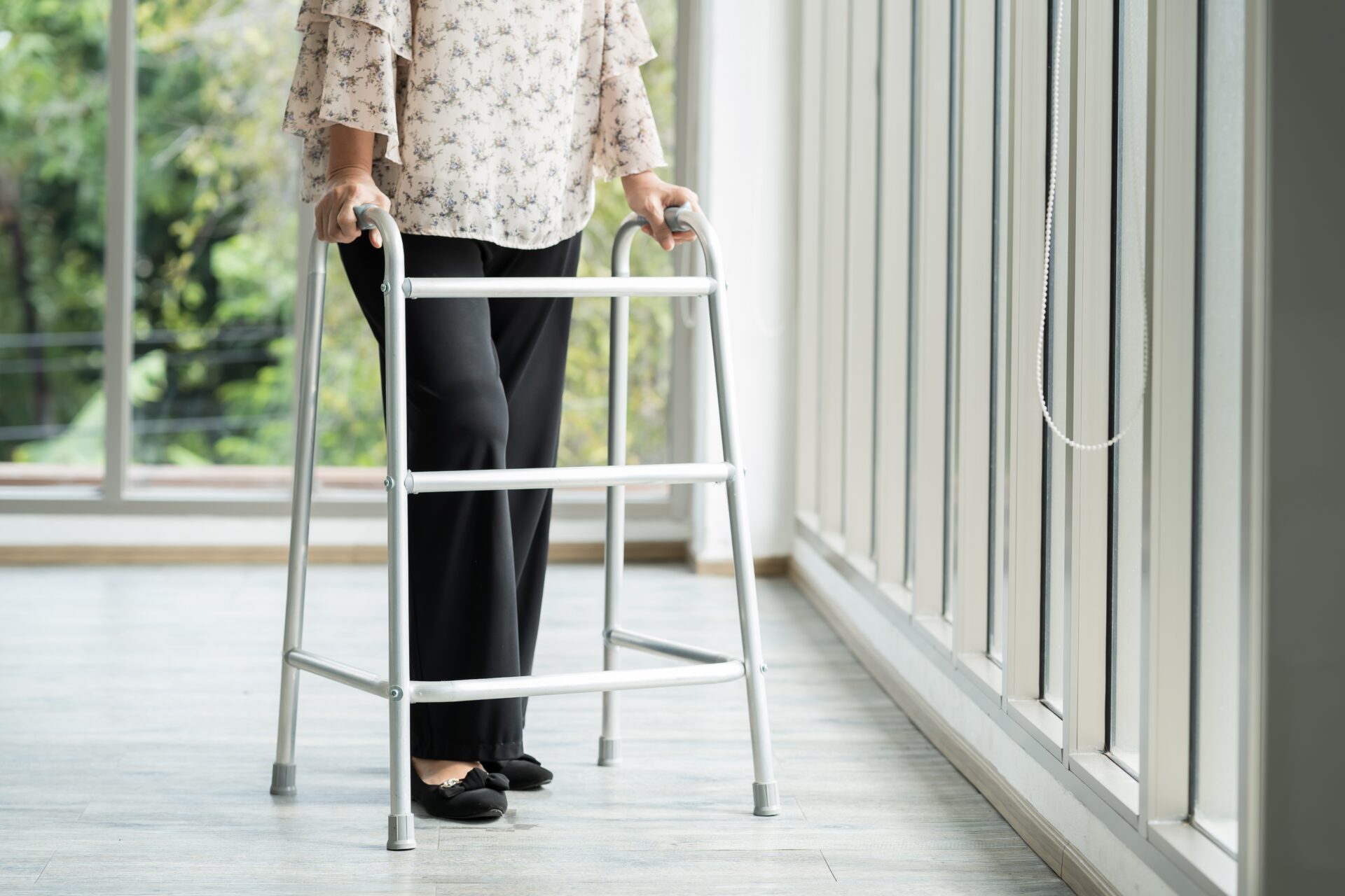 A patient uses a walker for mobility post hip replacement surgery. Walking unassisted is one of the major milestones of recovery.